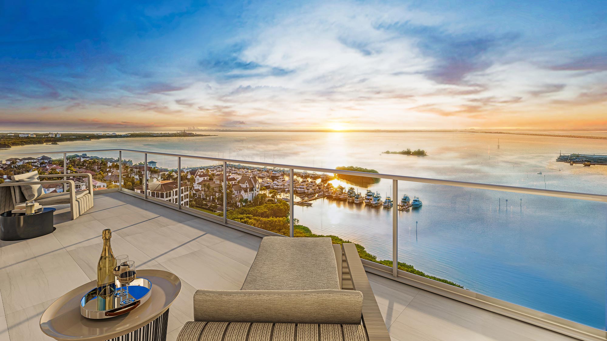 Rooftop terrace with modern furniture and glass railings, overlooking Tampa Bay marina, boats, and sunset views.